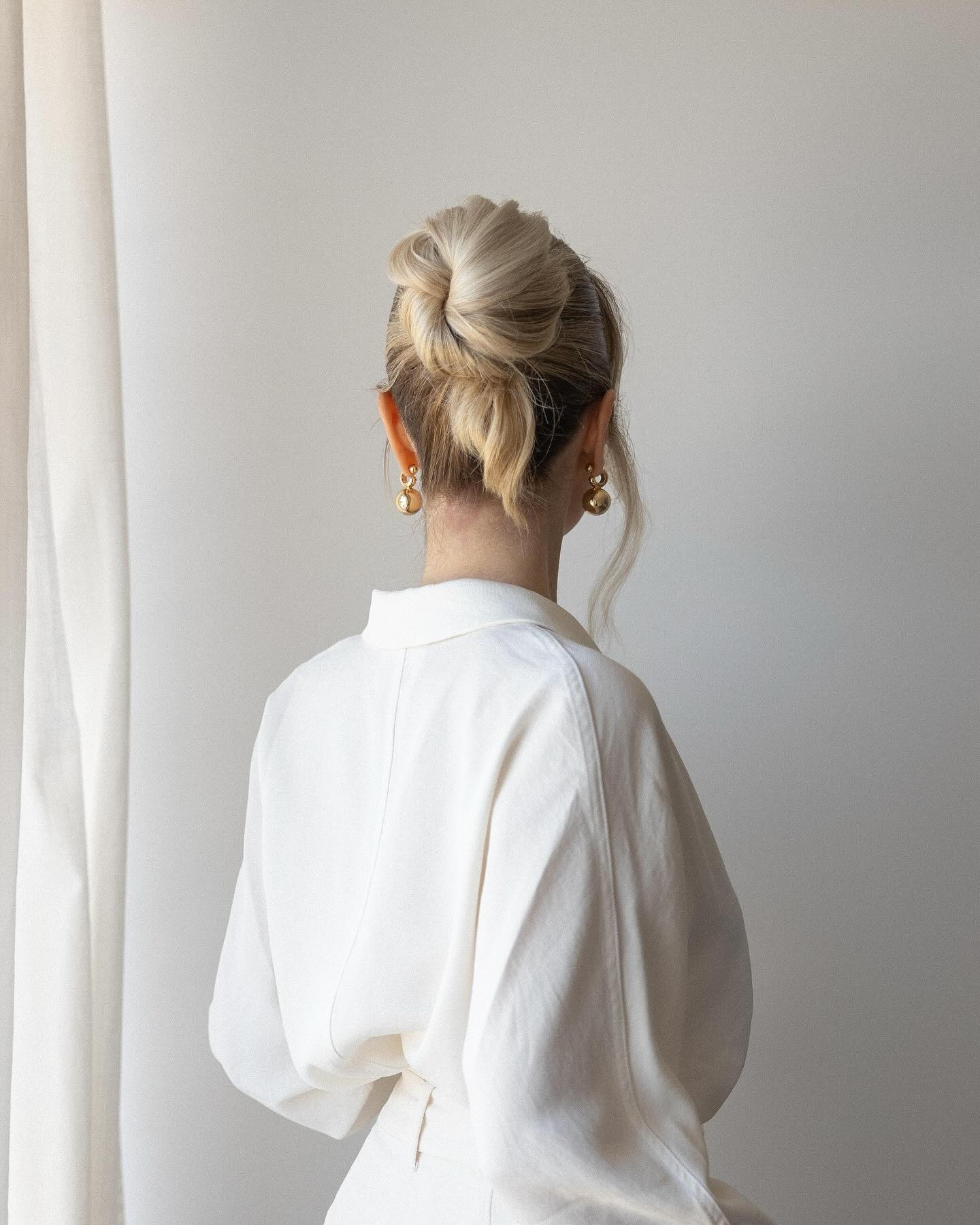 Sleek Low Bun with Statement Earrings