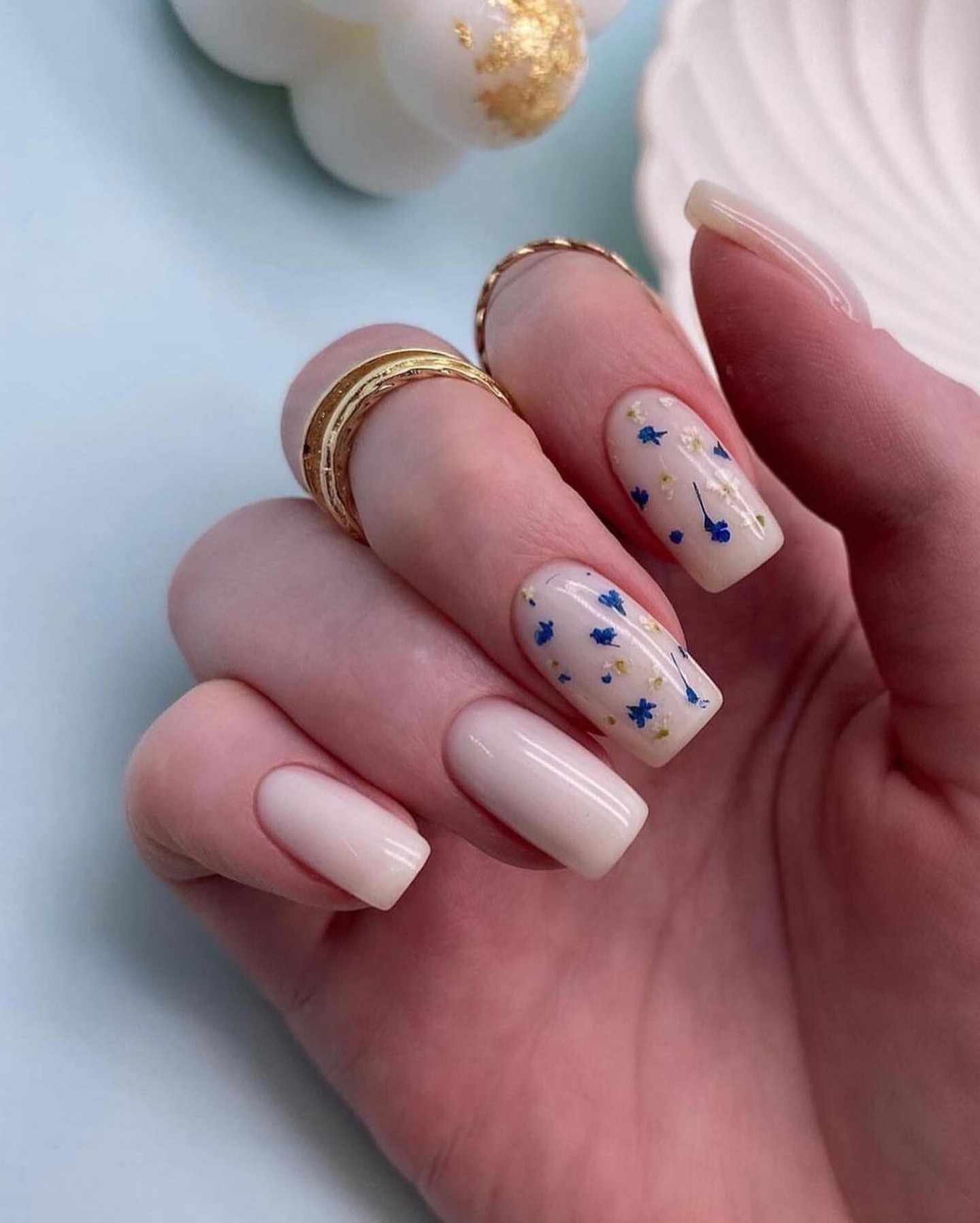 Chic Nude Nails with Blue Flower Accents